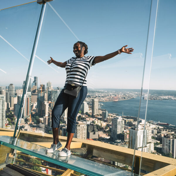 Woman leaning up against glass walls of the observatory deck